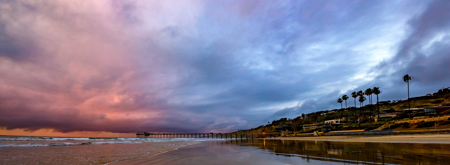 blue and pink storm clouds over the ocean and Scripps Pier